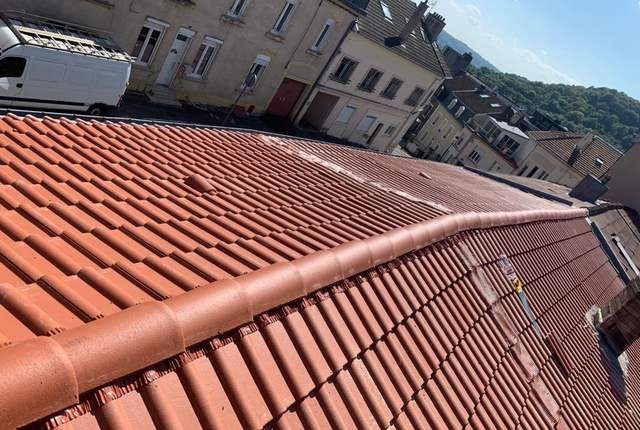 Arête de toiture en tuiles au-dessus d'une rue de maisons mitoyennes