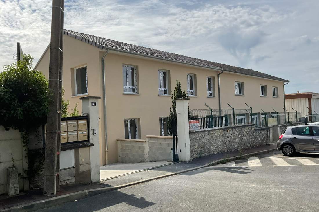 Long bâtiment enduit en bord de rue, façade rénovée sur toute sa longueur