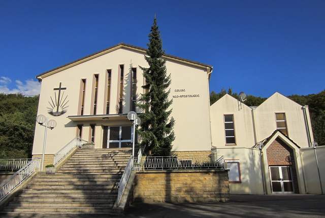 Église néo-apostolique d'Algrange, façade claire à pignon et grande croix, escalier d'accès