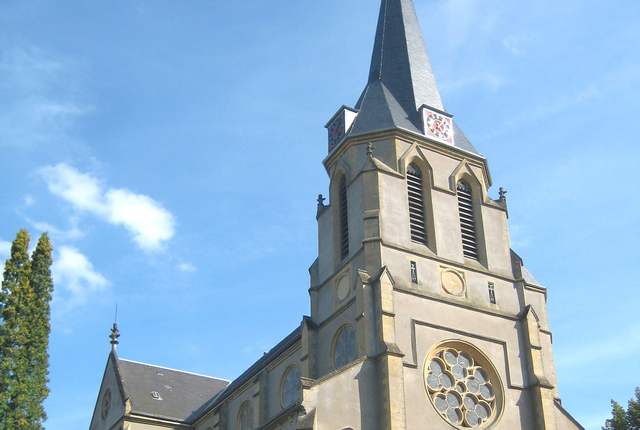 Église Saint-Jean-Baptiste d'Algrange, clocher à flèche d'ardoise au-dessus des arbres
