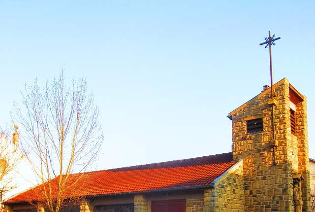 Chapelle de Haute-Ham, petit édifice à clocher-tour sur une place pavée