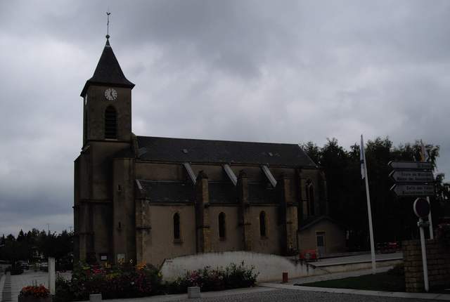 Église Notre-Dame de Bousse, nef en pierre et clocher couvert d'ardoise sous un ciel gris