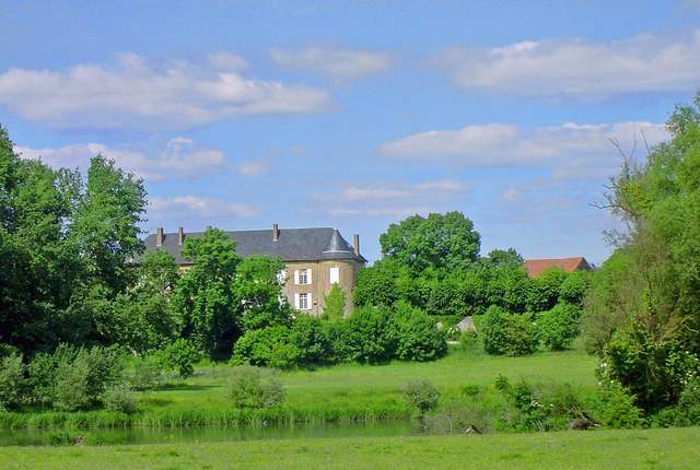 Château de Bousse dans la verdure, façade claire et toits d'ardoise