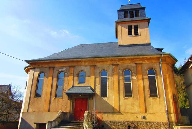 Temple protestant de Fontoy, édifice ocre à clocheton et porte rouge