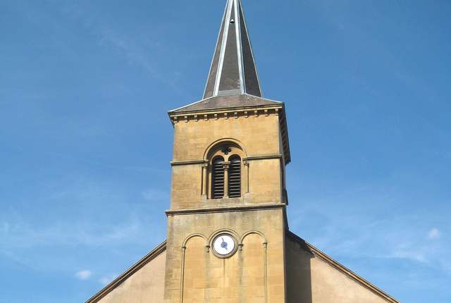 Église de Knutange, façade en pierre claire et clocher à flèche