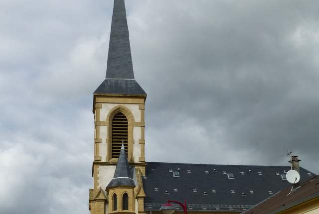 Église de Kuntzig, clocher à flèche d'ardoise et façade claire