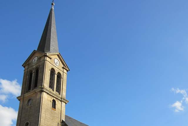 Église d'Ottange, clocher à flèche d'ardoise et nef en pierre