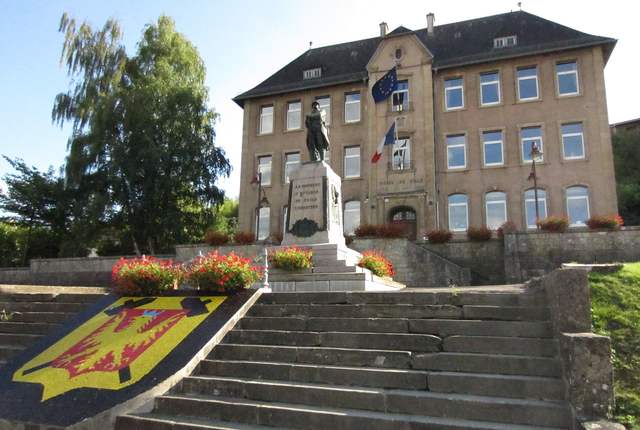 Mairie d'Ottange, bâtiment en pierre en haut d'un escalier fleuri