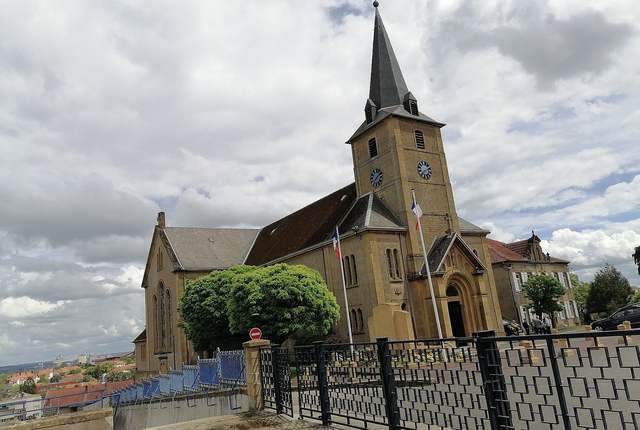 Église Saint-Rémi de Rombas sur sa butte, clocher à flèche et nef en pierre