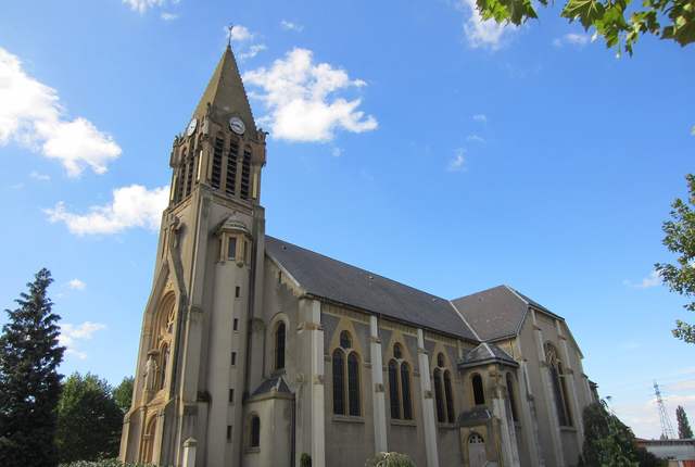 Église de Talange, nef en pierre et clocher à flèche sous un ciel bleu