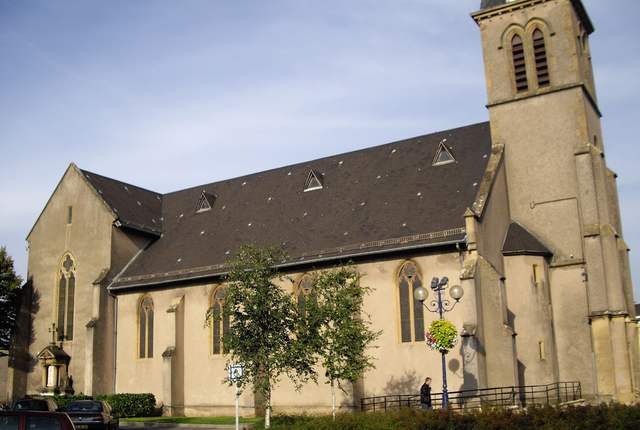 Église Sainte-Barbe d'Uckange, clocher carré et nef en pierre grise