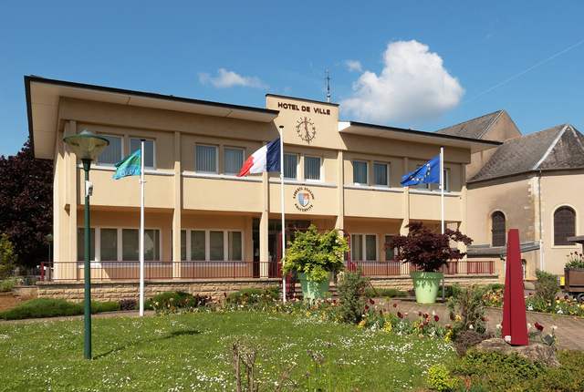 Mairie de Volmerange-les-Mines, façade claire à drapeaux et jardin
