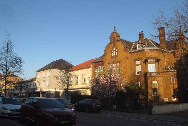 Maisons de brique et clocher à Yutz, rue du centre au soleil