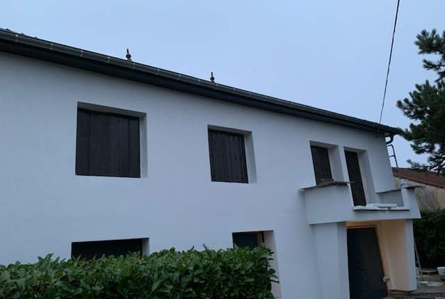 Maison en cours de ravalement, enduit gris clair fraîchement appliqué