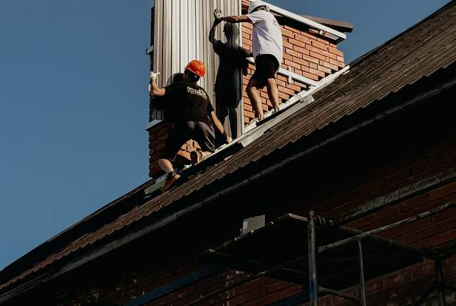 Habillage métallique d'une souche de cheminée en cours de pose au-dessus du toit