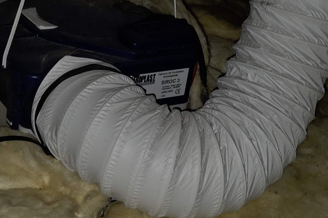 Isolant et gaine de ventilation posés dans un comble