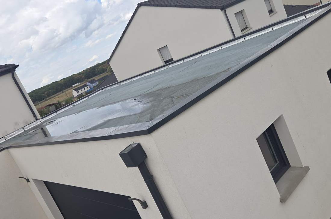 Toit plat terminé sur une maison neuve, couvertines en métal sur le haut des murs