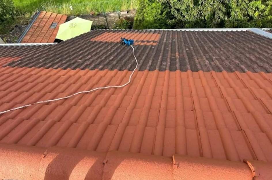 Pan de tuiles en cours de traitement : résine rouge sur le bas du toit, rangs du haut encore sombres