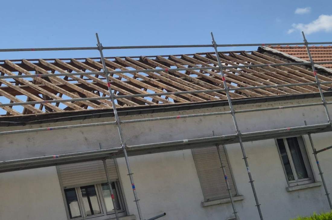 Toiture déposée jusqu'à la charpente sur une maison sous échafaudage