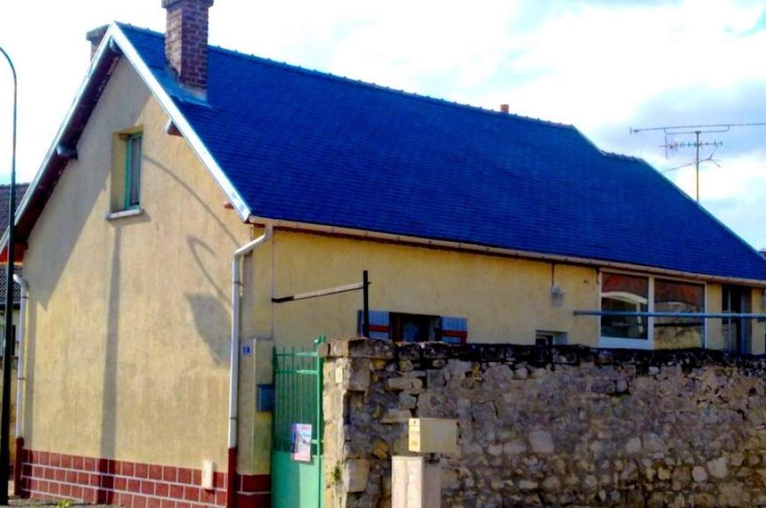 Maison dont la toiture a été peinte, tuiles uniformément recolorées