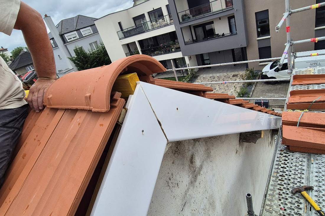 Pose des tuiles de rive, appuyées sur la planche neuve